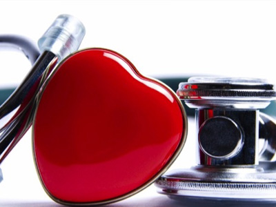 Close up of a stethoscope with a red, shiny heart next to it