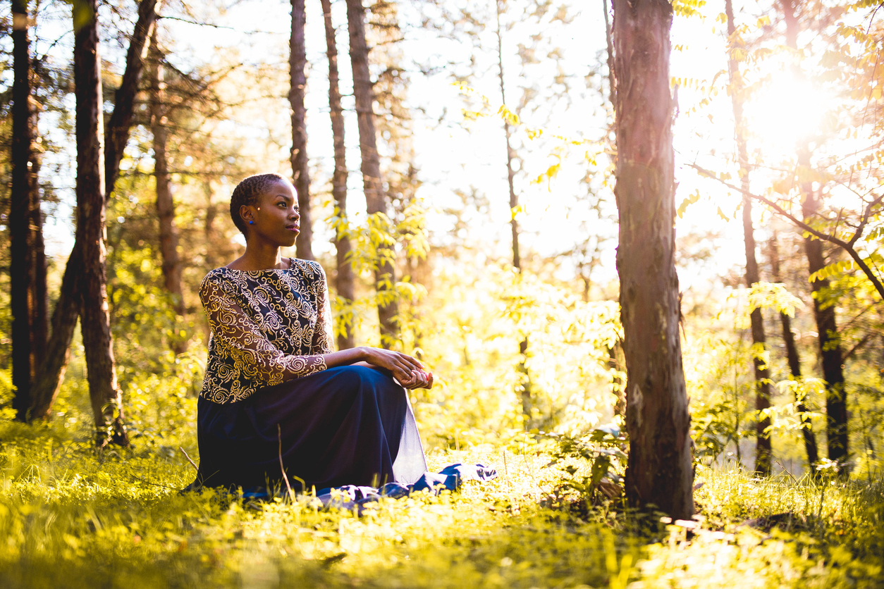 person sitting in woods breathing deeply