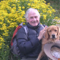 a man in a coat with a golden retriever 