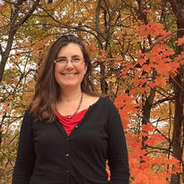 Julia Nerbonne standing in front of some fall foliage