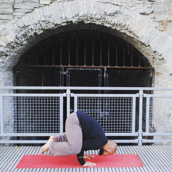 A man performing the Crane yoga pose