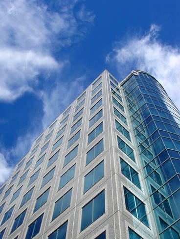 office tower against bright blue sky with white wispy clouds