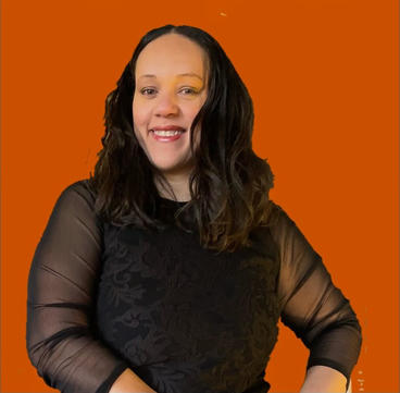 Rhonda Chakolis smiling at the camera with a plain orange background