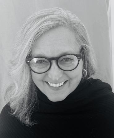 molly sturges - a black and white photo of a woman with glasses smiling